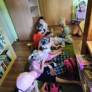Dzieci słuchają bajki czytanej przez bibliotekarkę